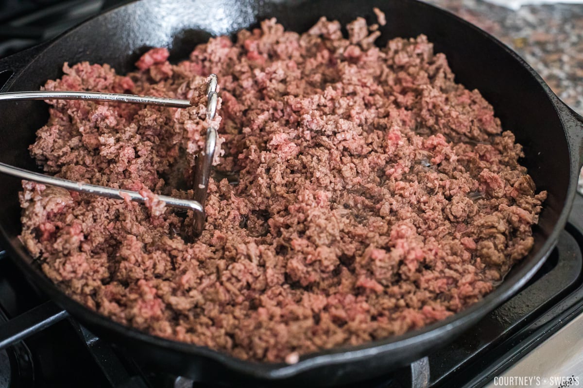 browning ground beef in a cast iron skillet.