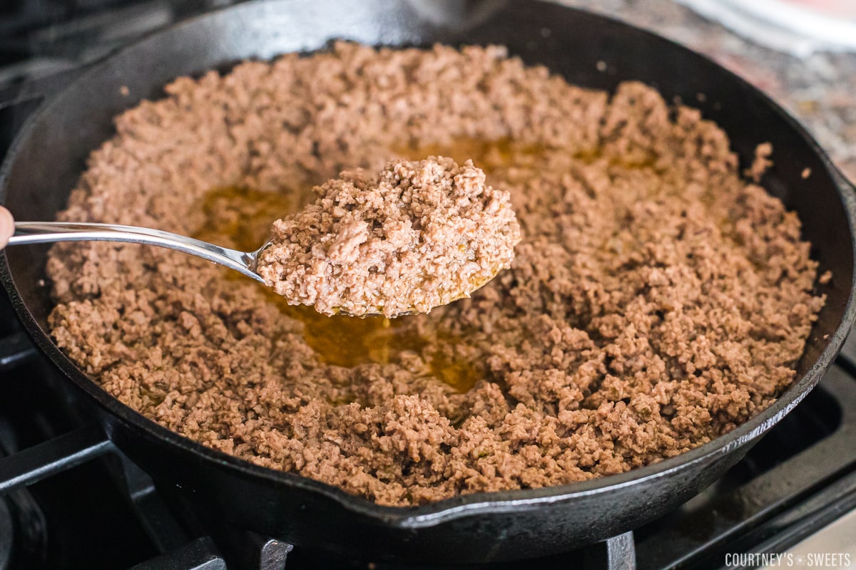 taco meat with spoon in cast iron skillet.