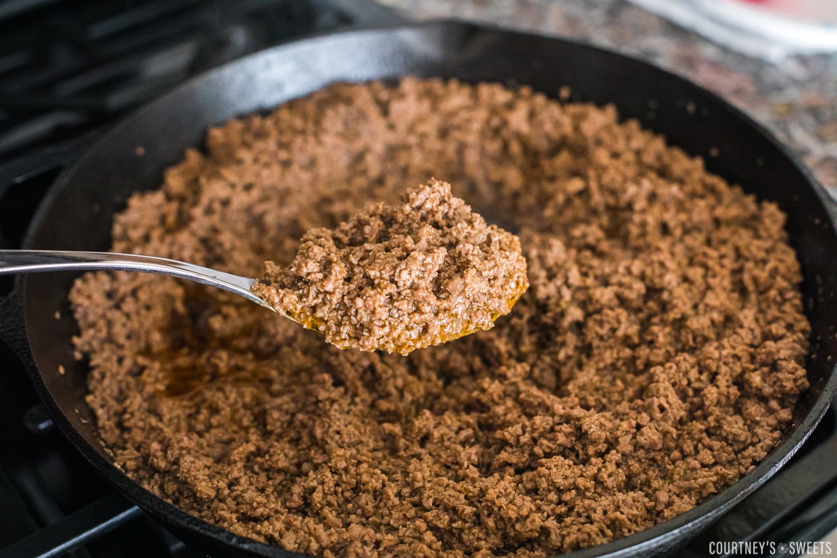 taco meat in cast iron skillet on a spoon.