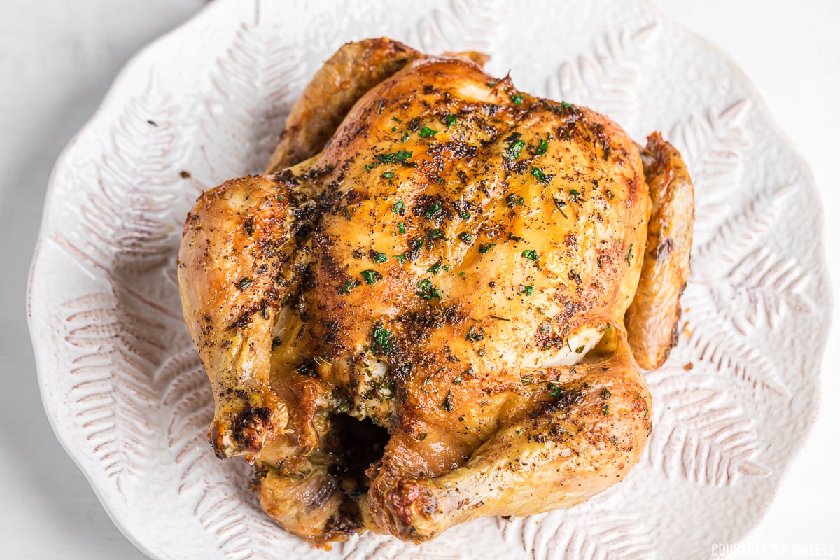 air fryer whole chicken on a white plater.