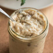 Close-up of homemade condensed cream of mushroom soup in a mason jar with visible mushroom pieces.