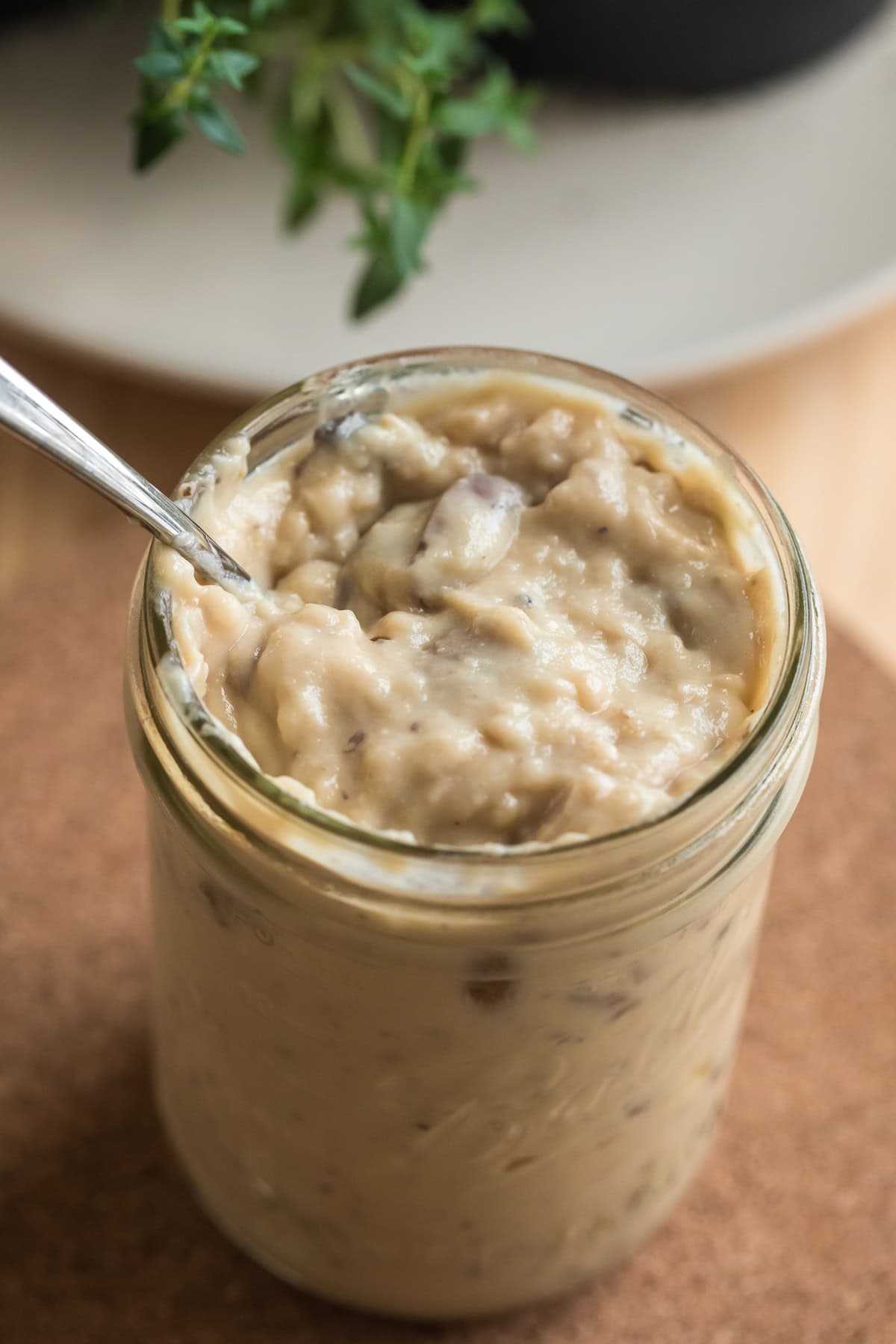 Close-up of homemade condensed cream of mushroom soup in a mason jar with visible mushroom pieces.