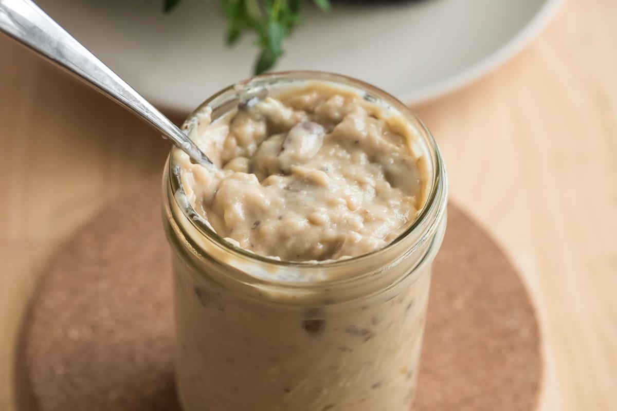 Homemade from-scratch condensed cream of mushroom soup in a mason jar with a spoon.