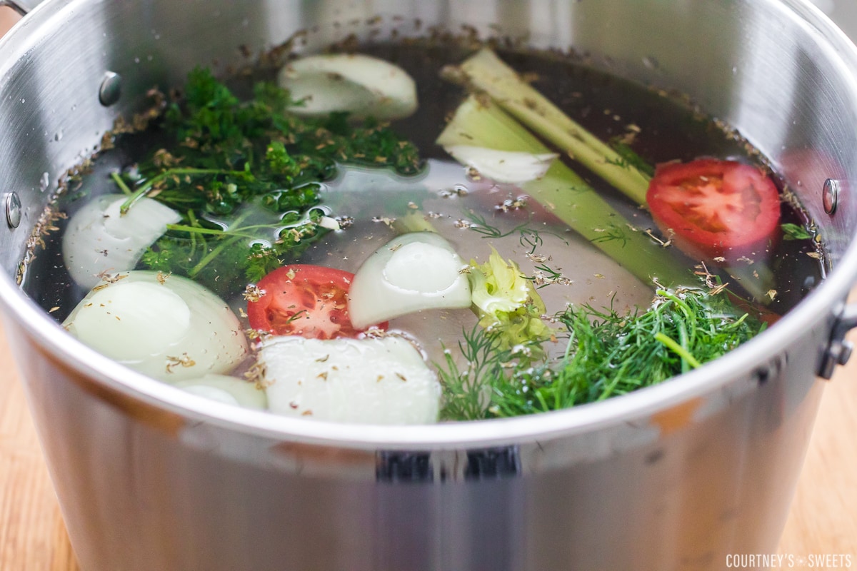 soup pot with vegetables, chicken, and water to make broth.