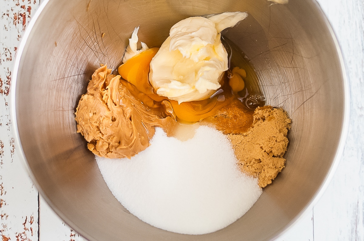 unmixed ingredients for peanut butter cookies in a stand mixer bowl.