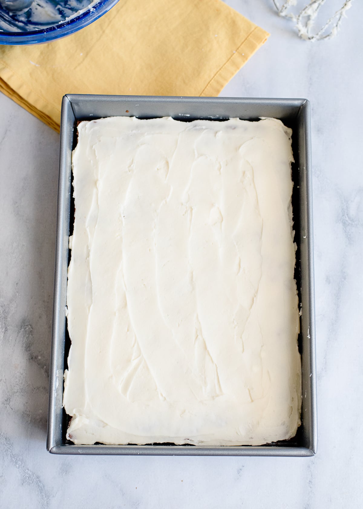 cooked banana nut cake in a baking dish with frosting.