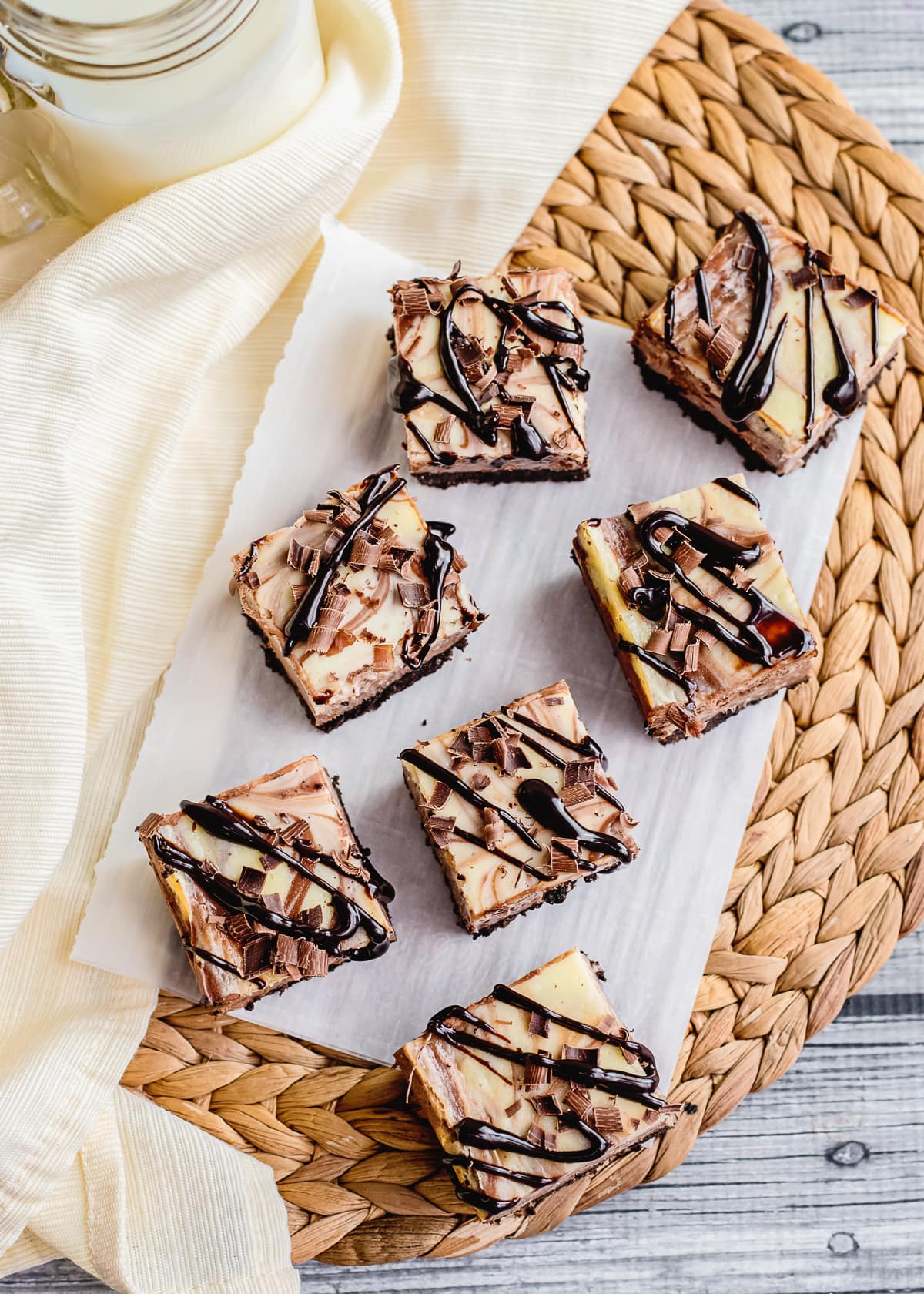 overhead photo of cheesecake bars with a chocolate drizzle.