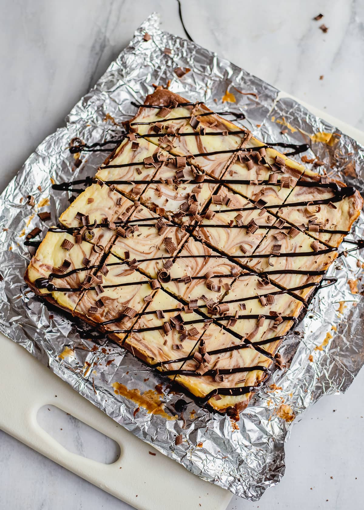 cheesecake bars sliced with chocolate drizzle.