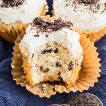 oreo cupcakes with vanilla buttercream and crushed oreos with bite taken out of the front one.