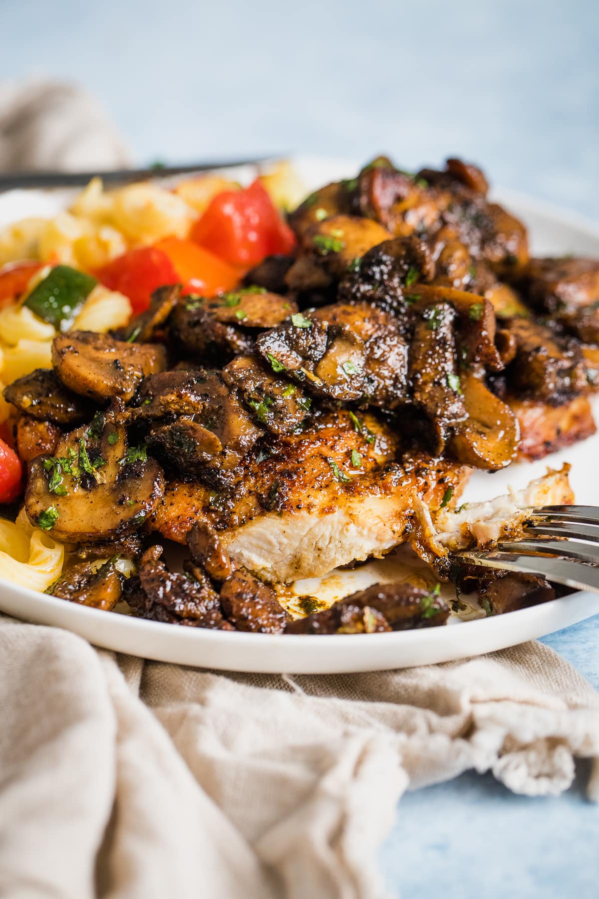 a piece of chicken and mushrooms cut into it showing the inside on a white plate.