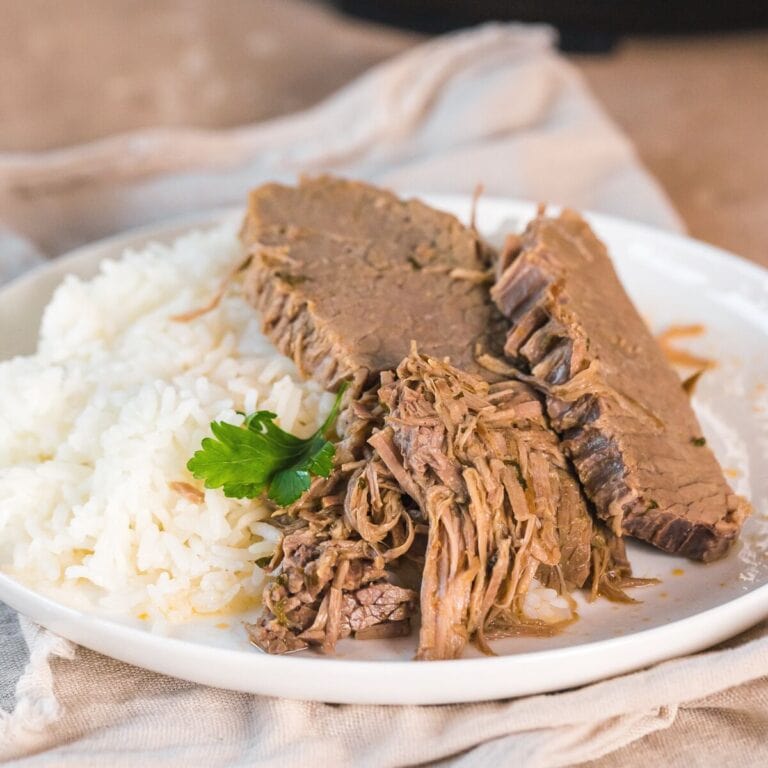 instant pot bottom round roast beef served with white rice on a plate.