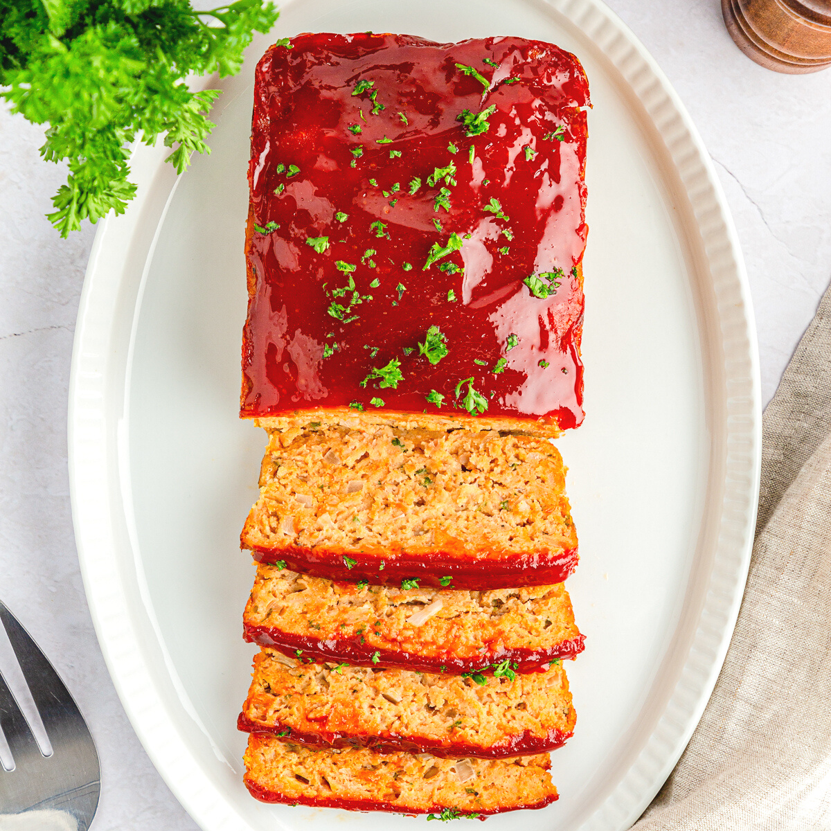 chicken meatloaf half sliced on a white platter.