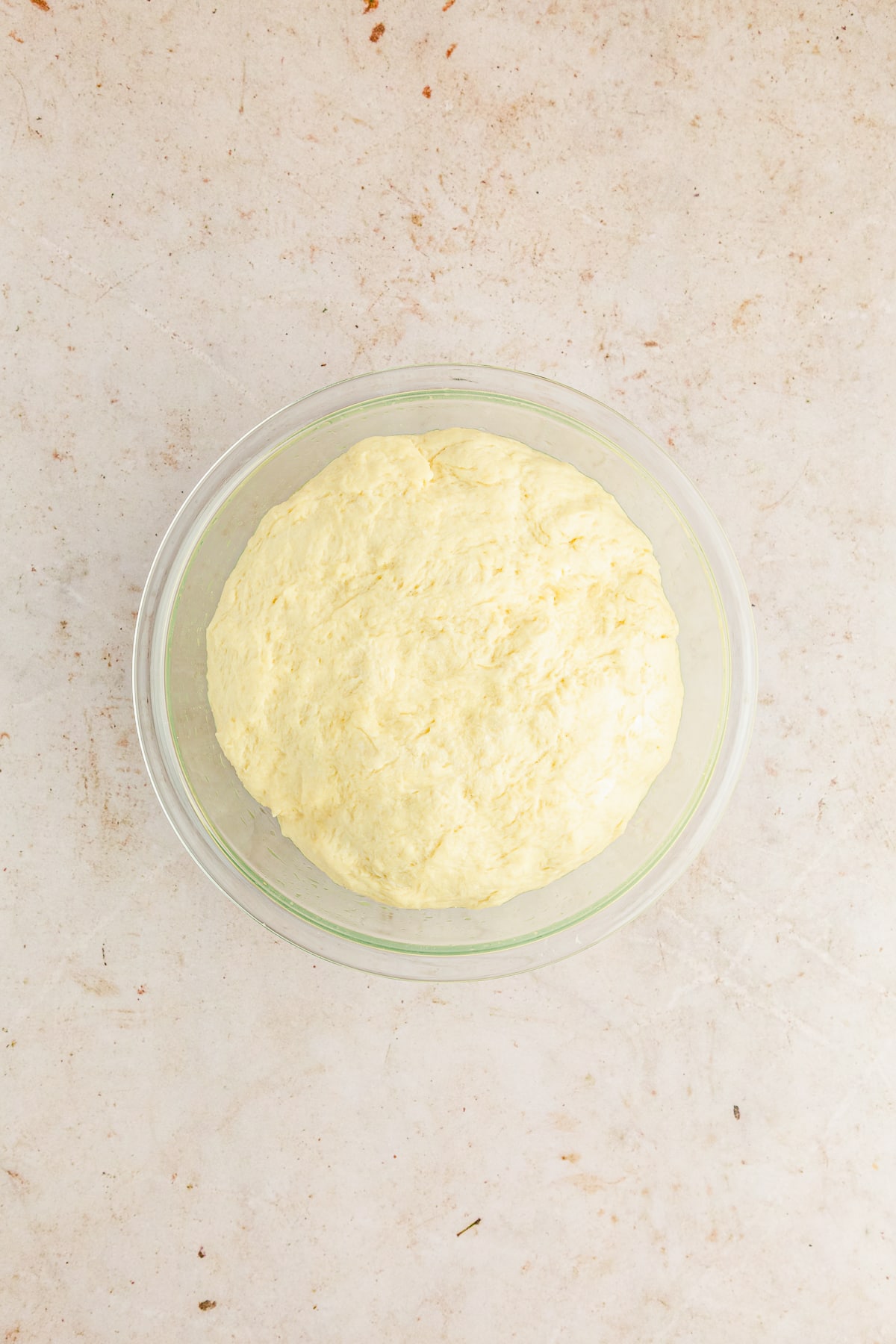 risen dough in a glass bowl.