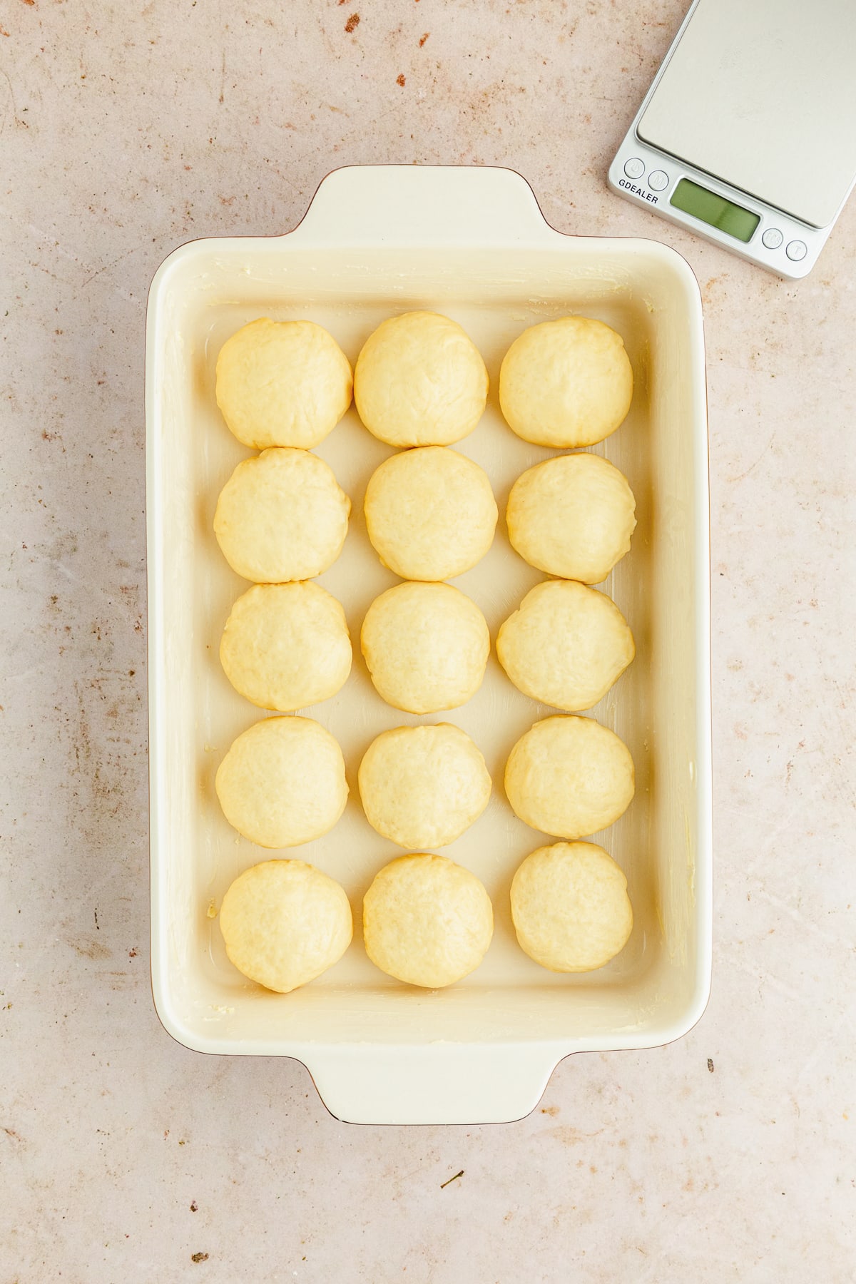 dinner rolls placed in a greased ceramic baking dish.