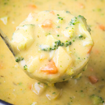 broccoli potato soup in a ladle over a dutch oven with soup in it.