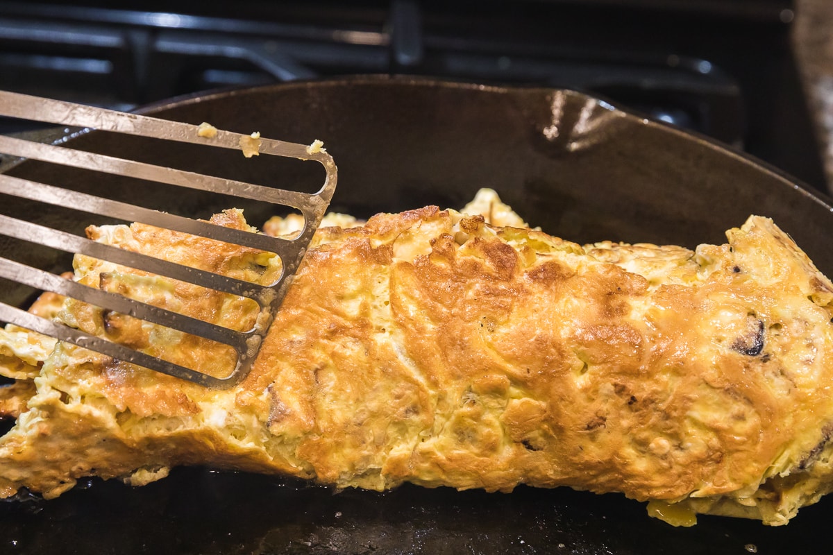 spatula flipping matzo brei halfway to show the crispy exterior.