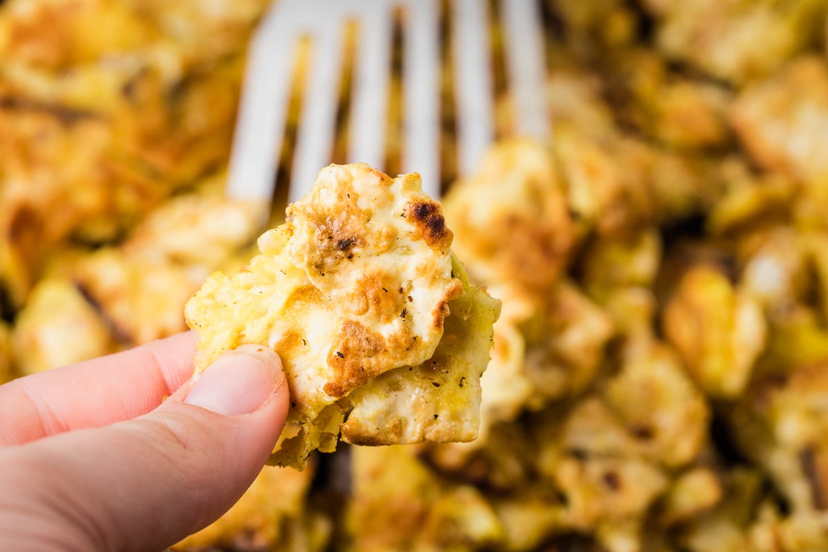 pointer and thumb fingers holding a piece of matzo brei.
