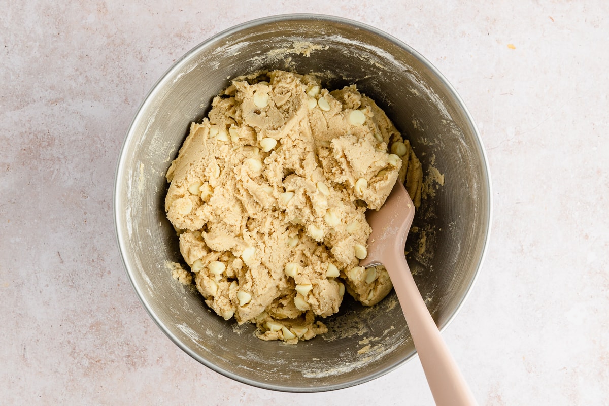 white chocolate chip cookie dough in a bowl with a spoon.