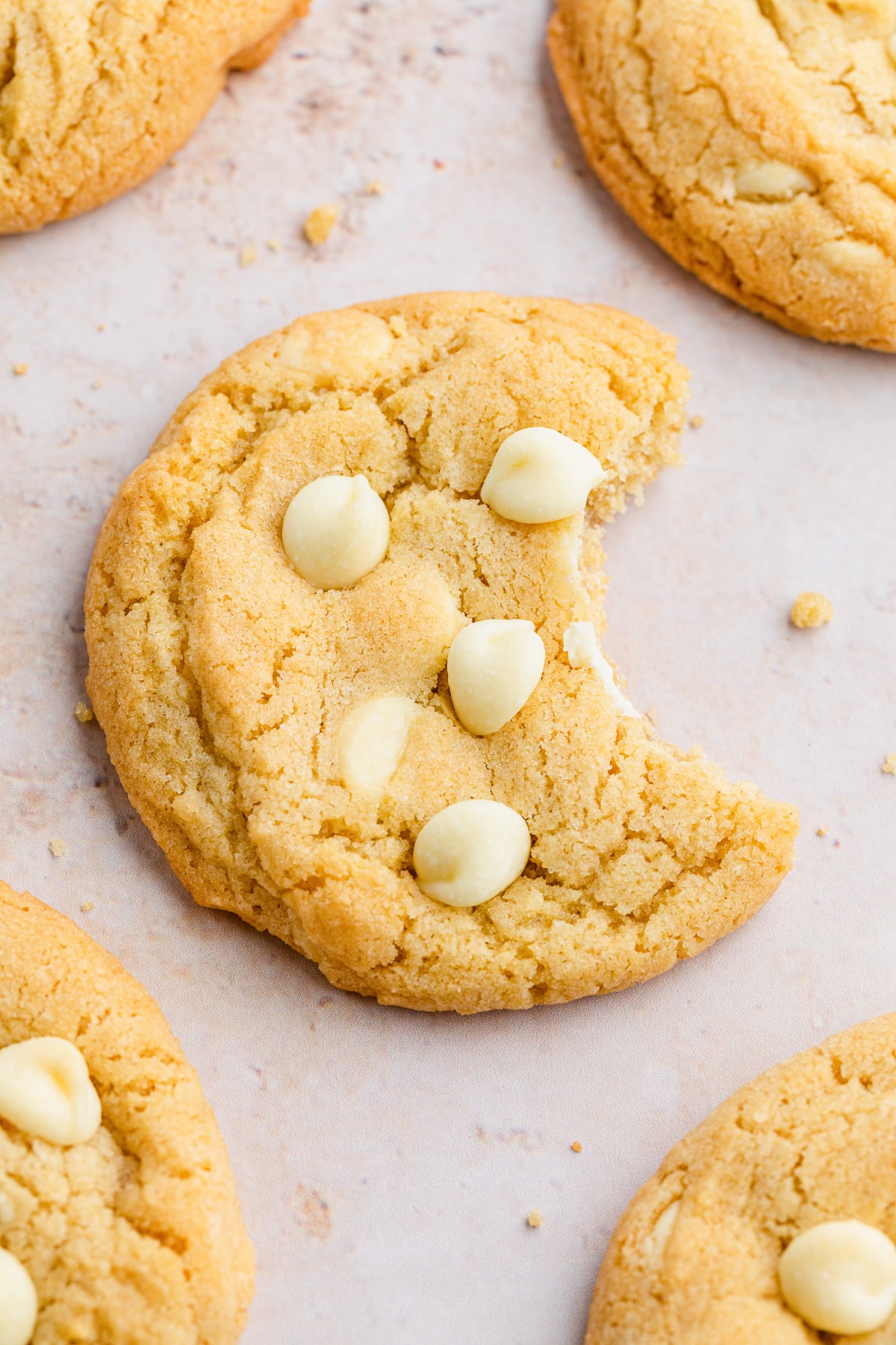 white chocolate chip cookie with bite taken out of it.