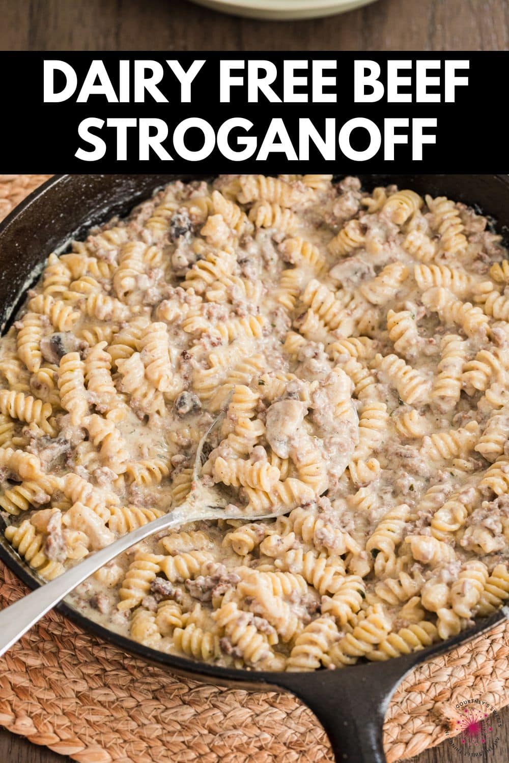 beef stroganoff in a cast iron skillet with serving spoon and text on image saying dairy free beef stroganoff.