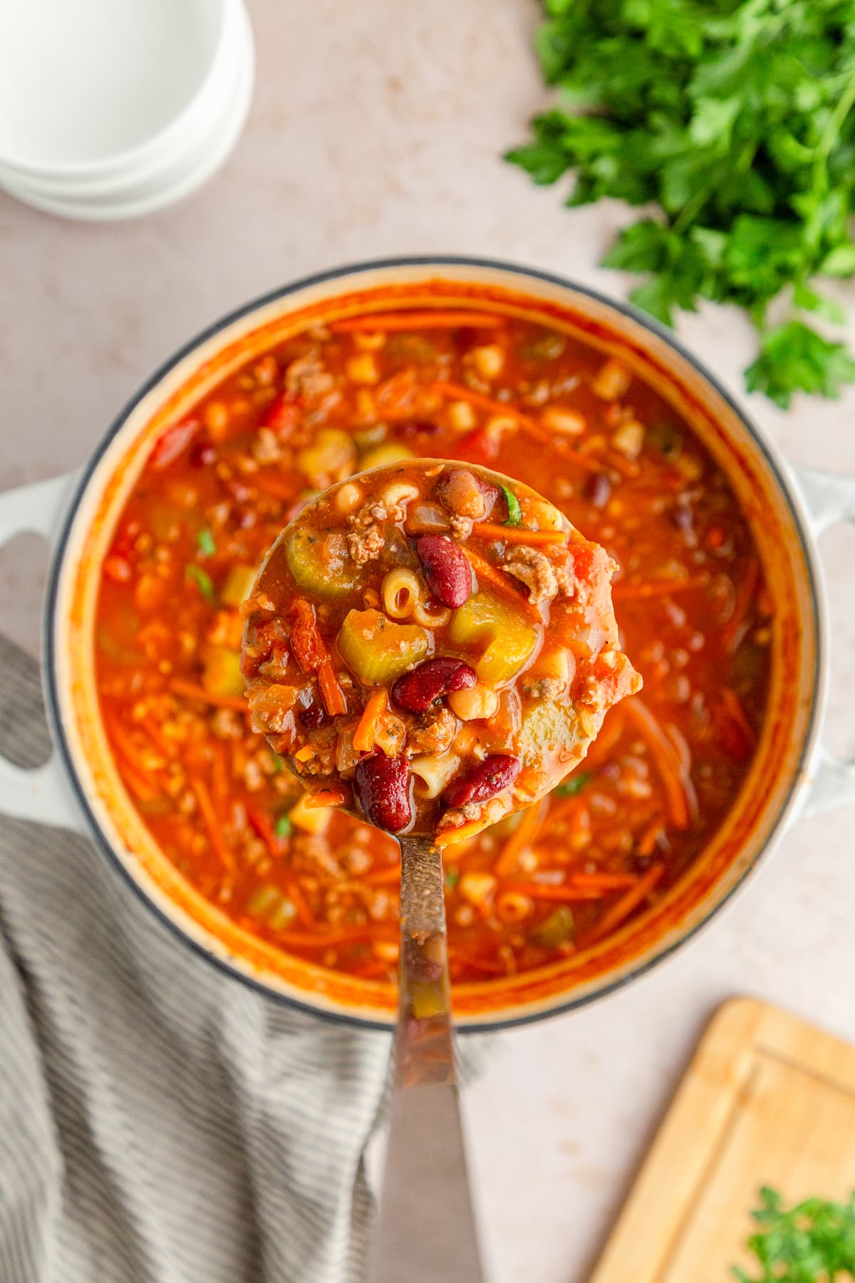 Pasta e Fagioli Soup on a ladle above a pot full of soup.