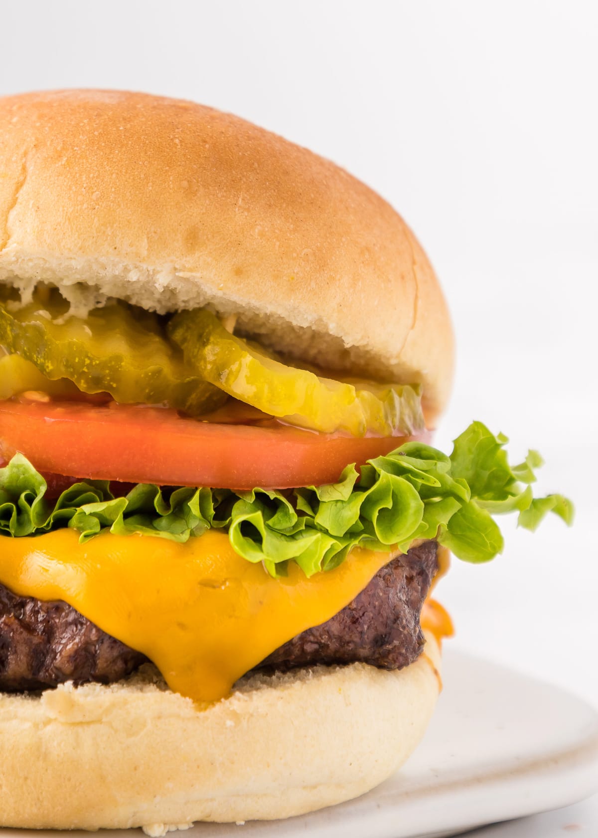 close up of a hamburger with cheese and toppings.