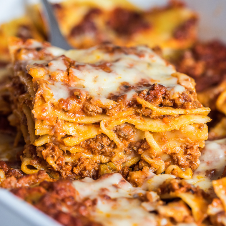 dairy free lasagna without ricotta slice on a metal spatula over the casserole dish.