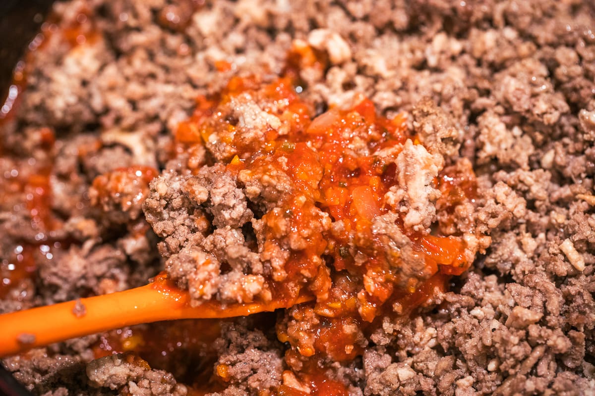 meat adding into red sauce.