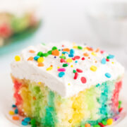 a piece of jello poke cake, rainbow colors on a plate.