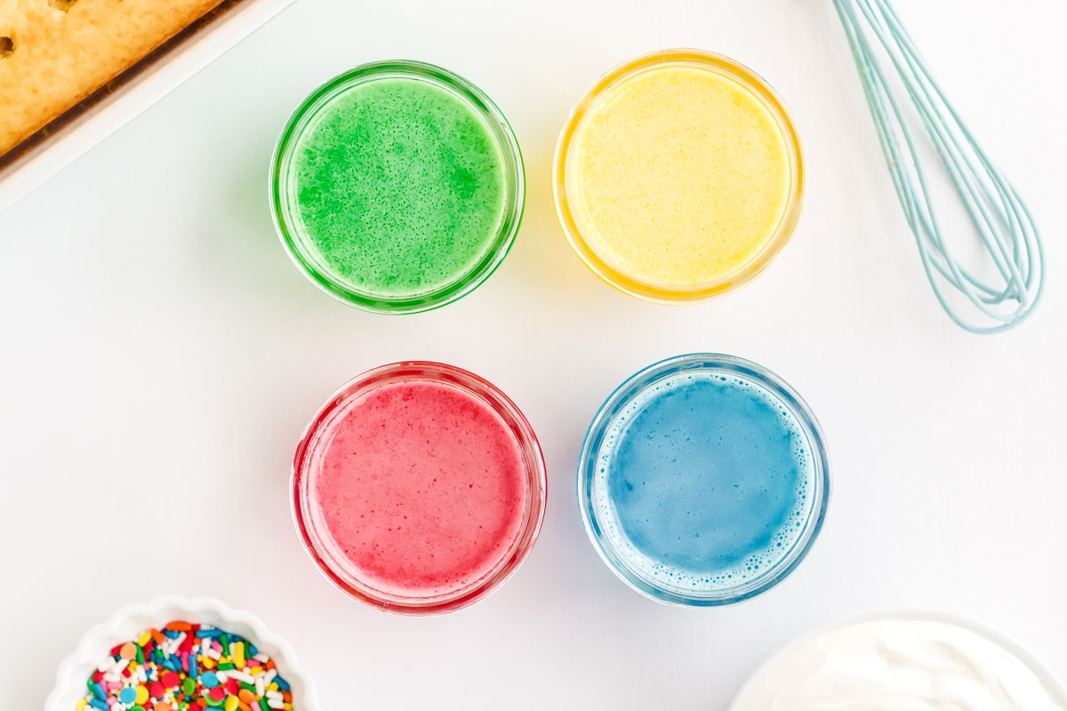 green, yellow, red, and blue jello in glass bowls to make a poke cake.