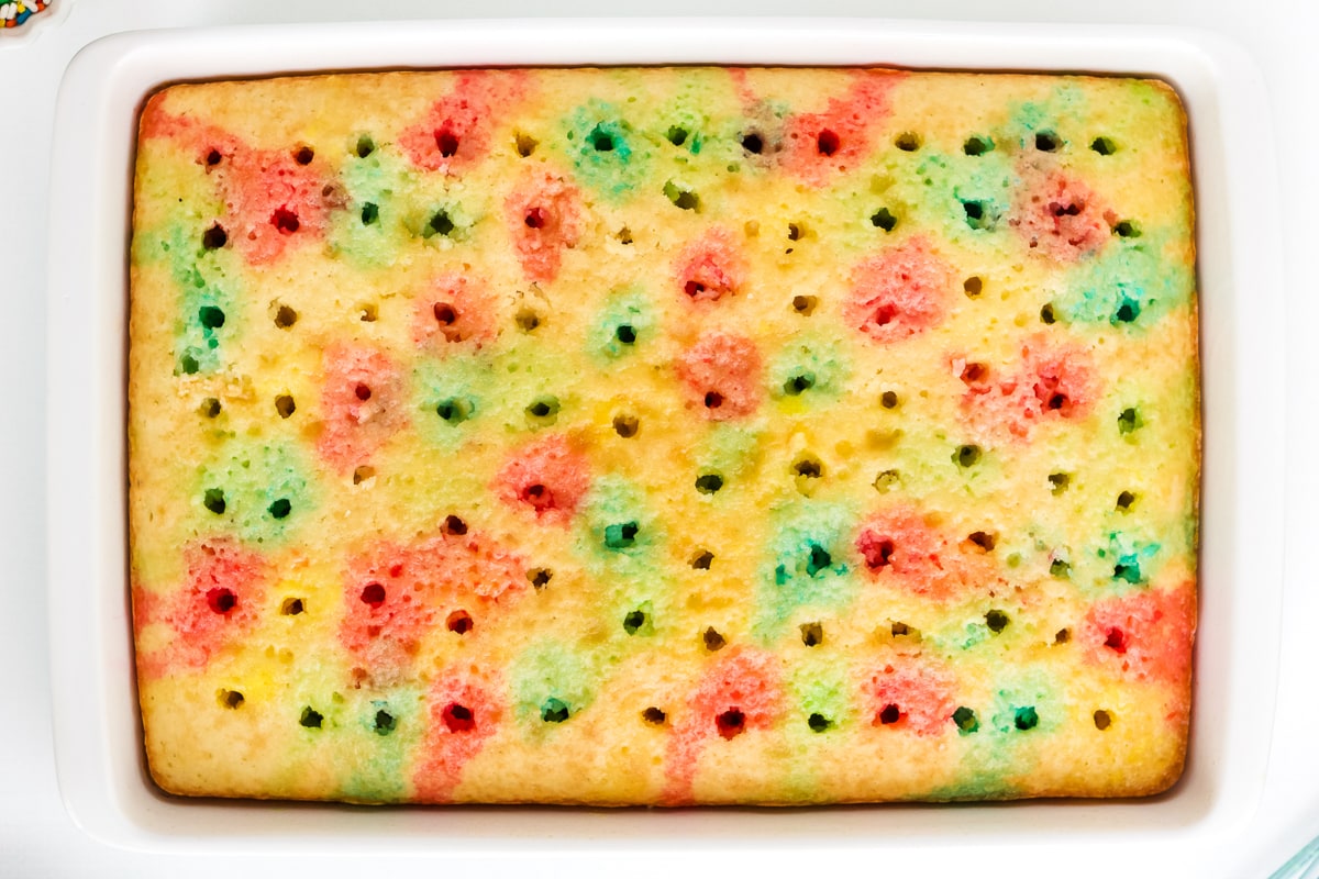 overhead photo of a cake with poke holes in it for jello to make a poke cake.