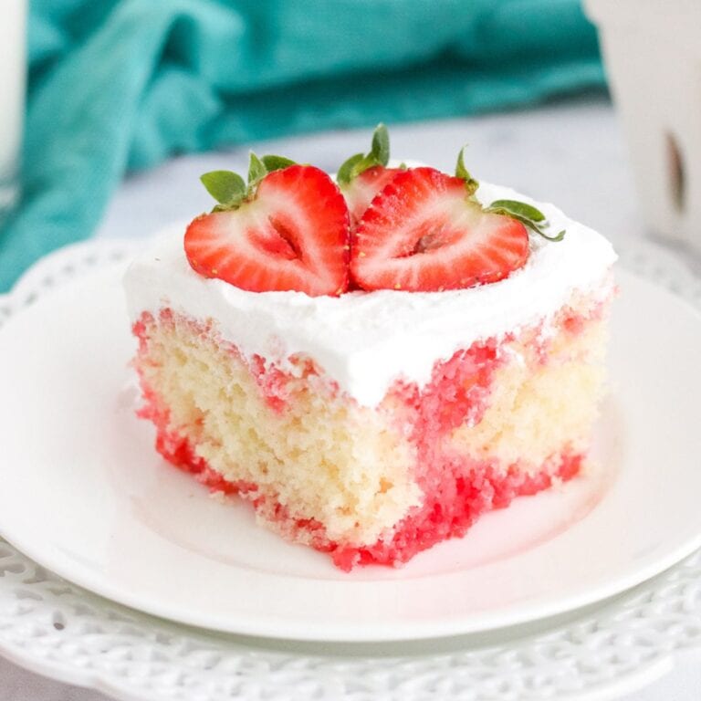 strawberry poke cake slice on a white plate.