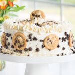 chocolate chip cake on a white cake stand.