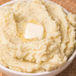 instant pot mashed potatoes in a bowl with a tab of butter.