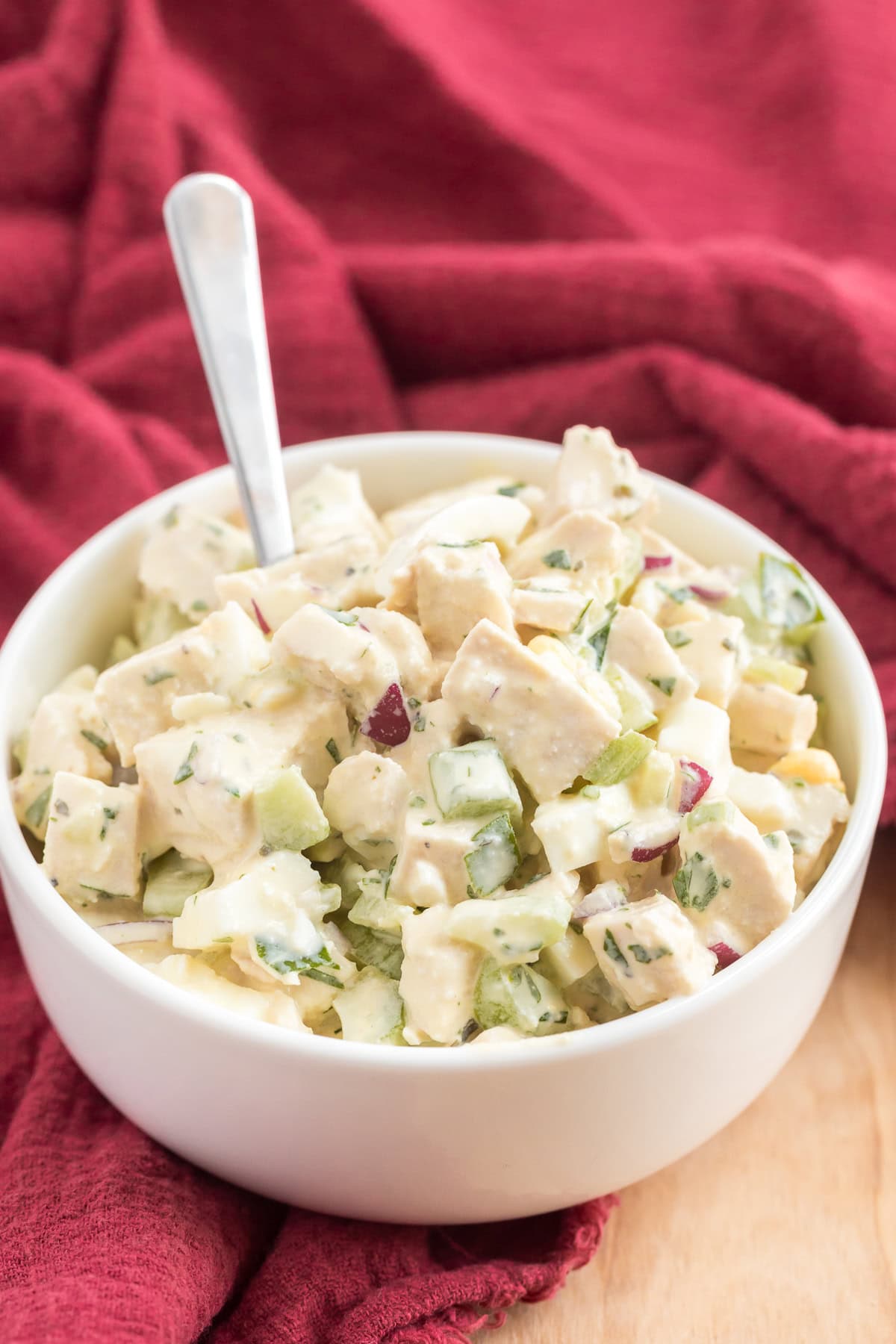 Freshly made salad with chunks of chicken, diced celery, red onion, and herbs coated in a creamy dressing.