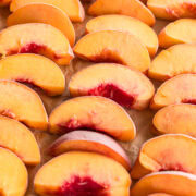 frozen peaches on a baking sheet lined with parchment paper.