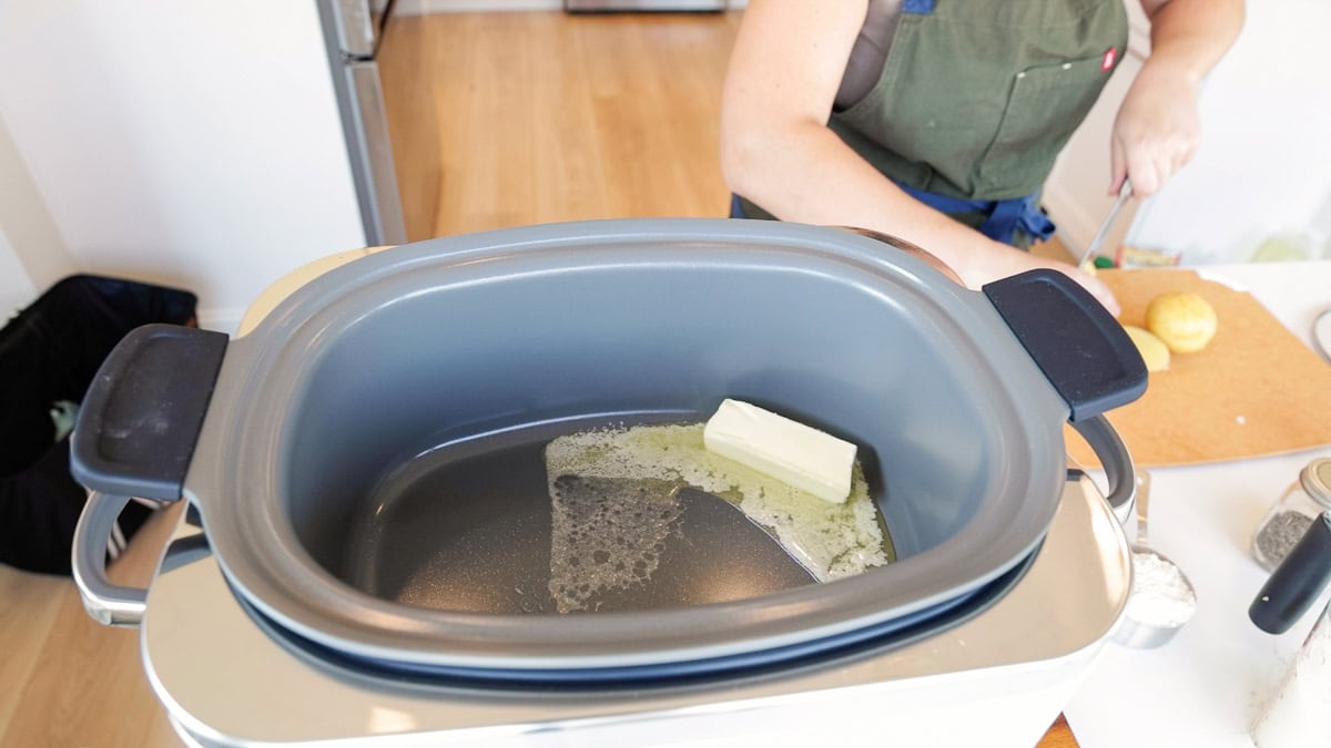 Butter melting directly in the GreenPan Elite slow cooker insert, step for making homemade chicken pot pie filling.