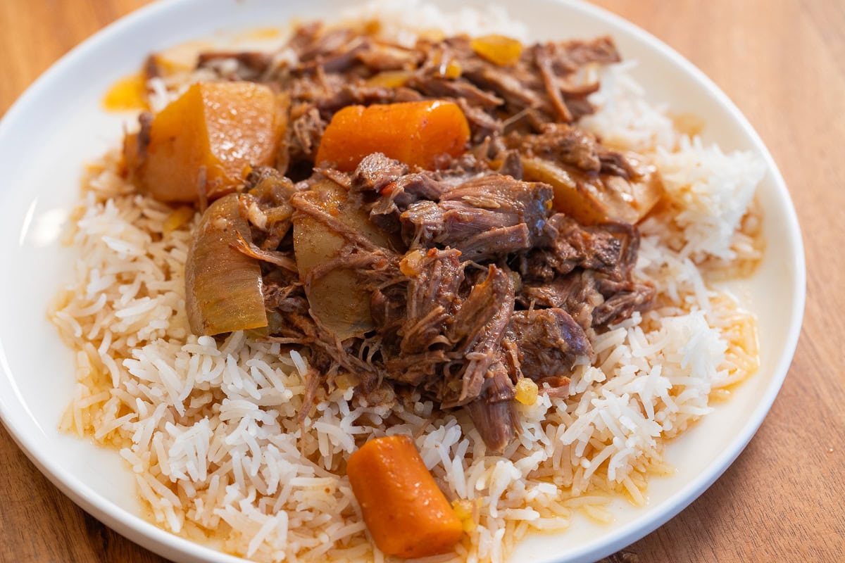Hearty pot roast dinner with carrots, potatoes, and rice.