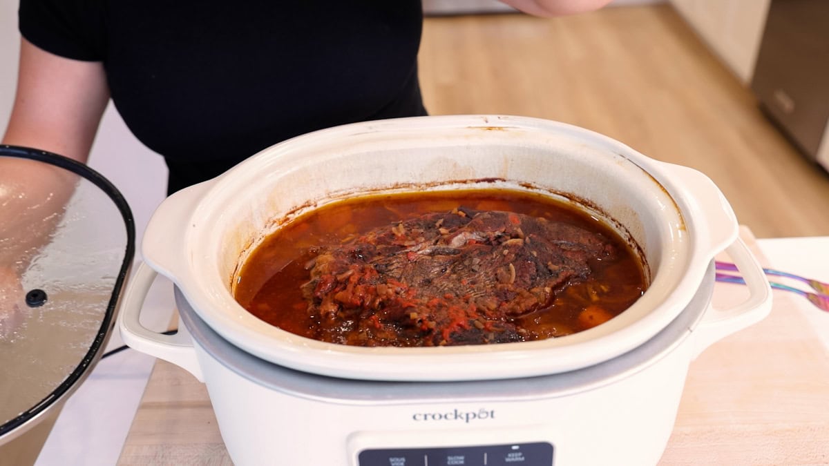 Chuck roast cooked in slow cooker with vegetables and sauce.