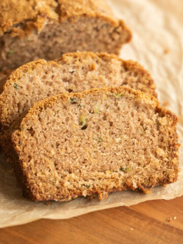 Zucchini bread slice close-up with melted chocolate chips and a golden brown crust.