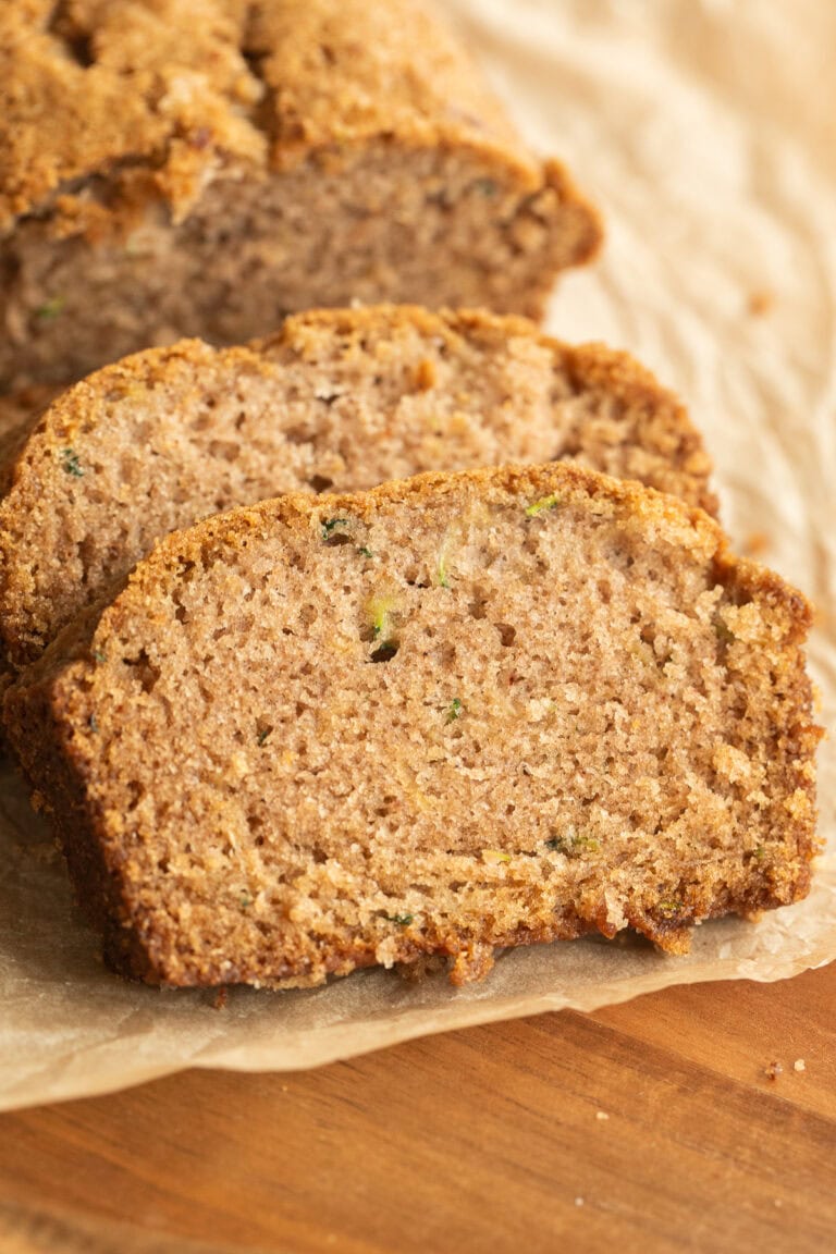 Zucchini bread slice close-up with melted chocolate chips and a golden brown crust.