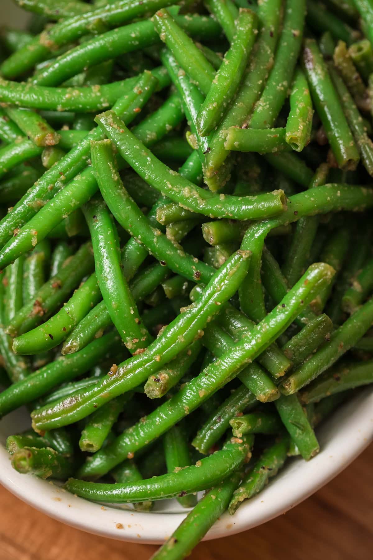 Close up of bright green garlic green beans showing the textured seasoning.