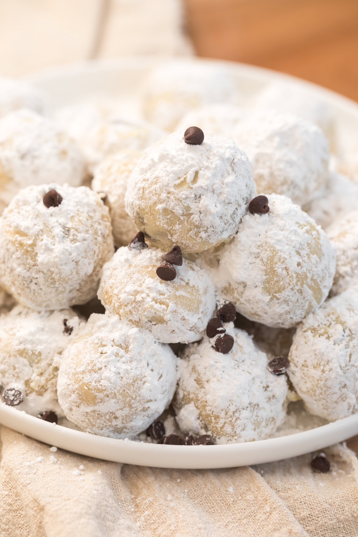 Chocolate chip snowball cookies piled high and dusted in powdered sugar.