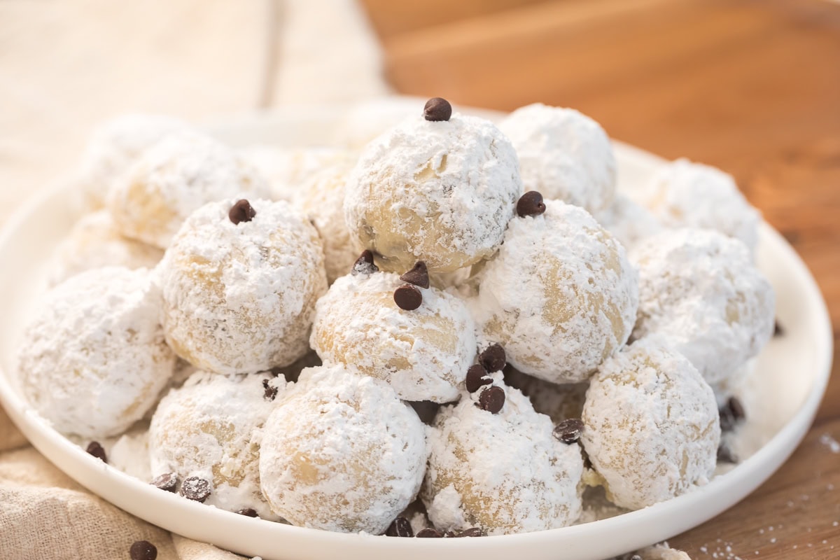Festive chocolate chip snowball cookies arranged on a plate for serving.