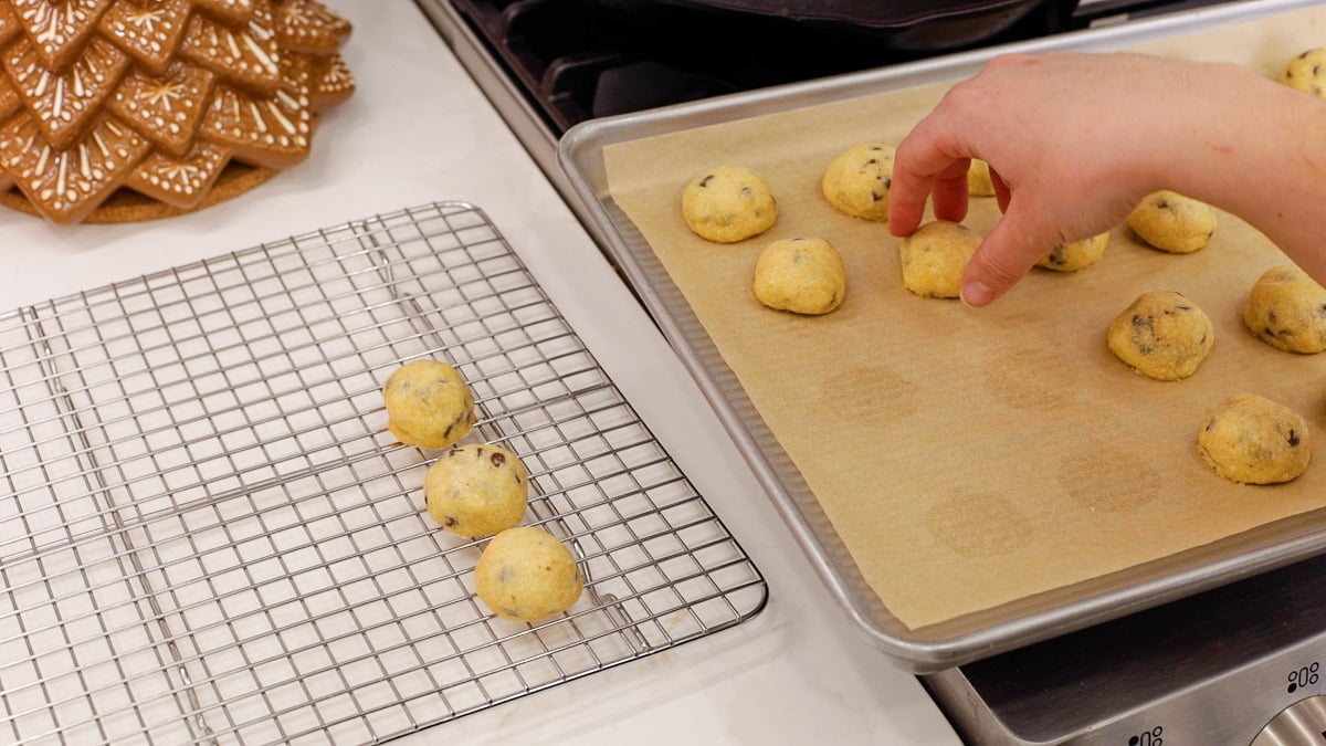 Hand transferring cookies to cooling rack.