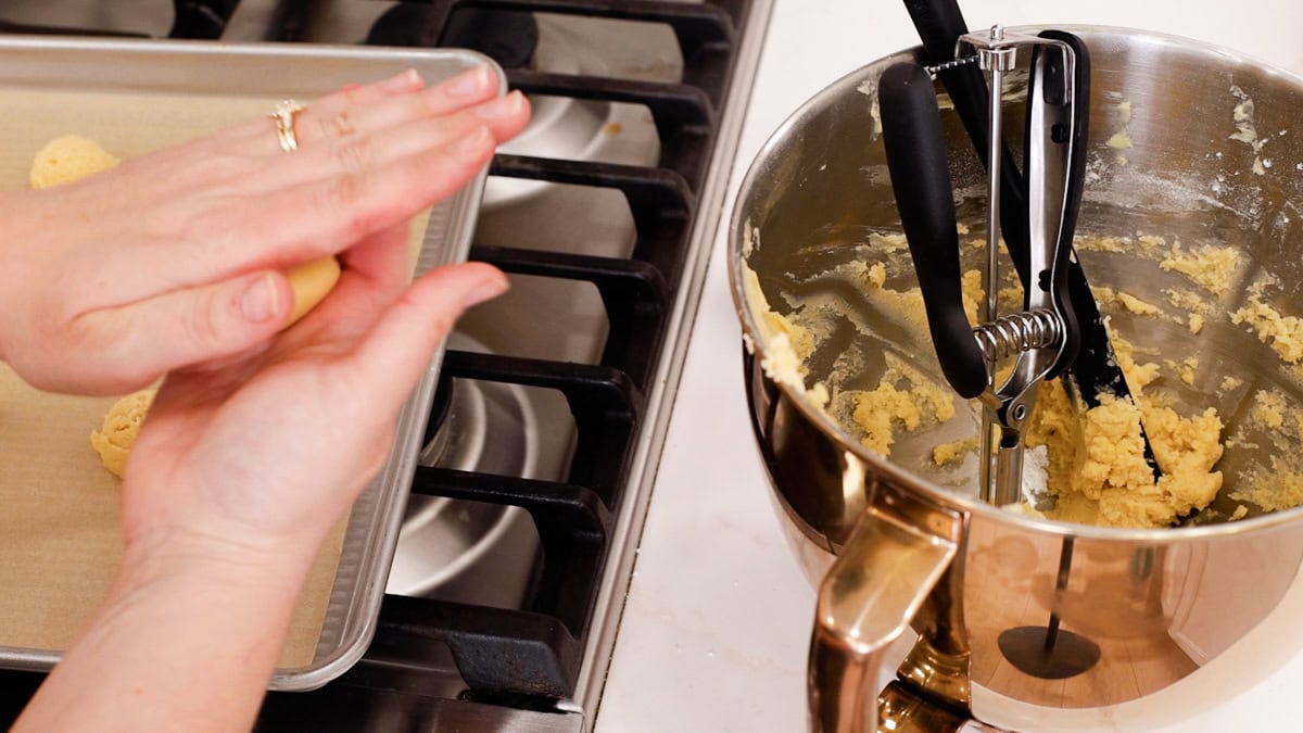 hands rolling snowball cookie dough.