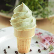 Mint soft serve ice cream cone with a light, airy swirl and smooth finish