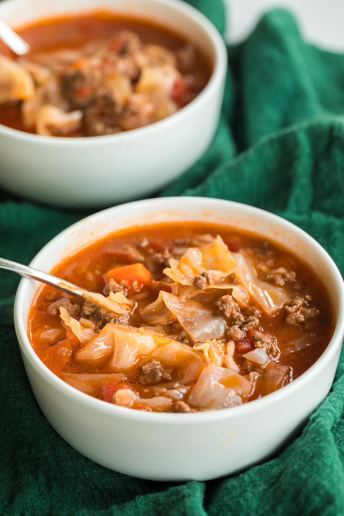 cabbage roll soup in a white bowl on green napkin.