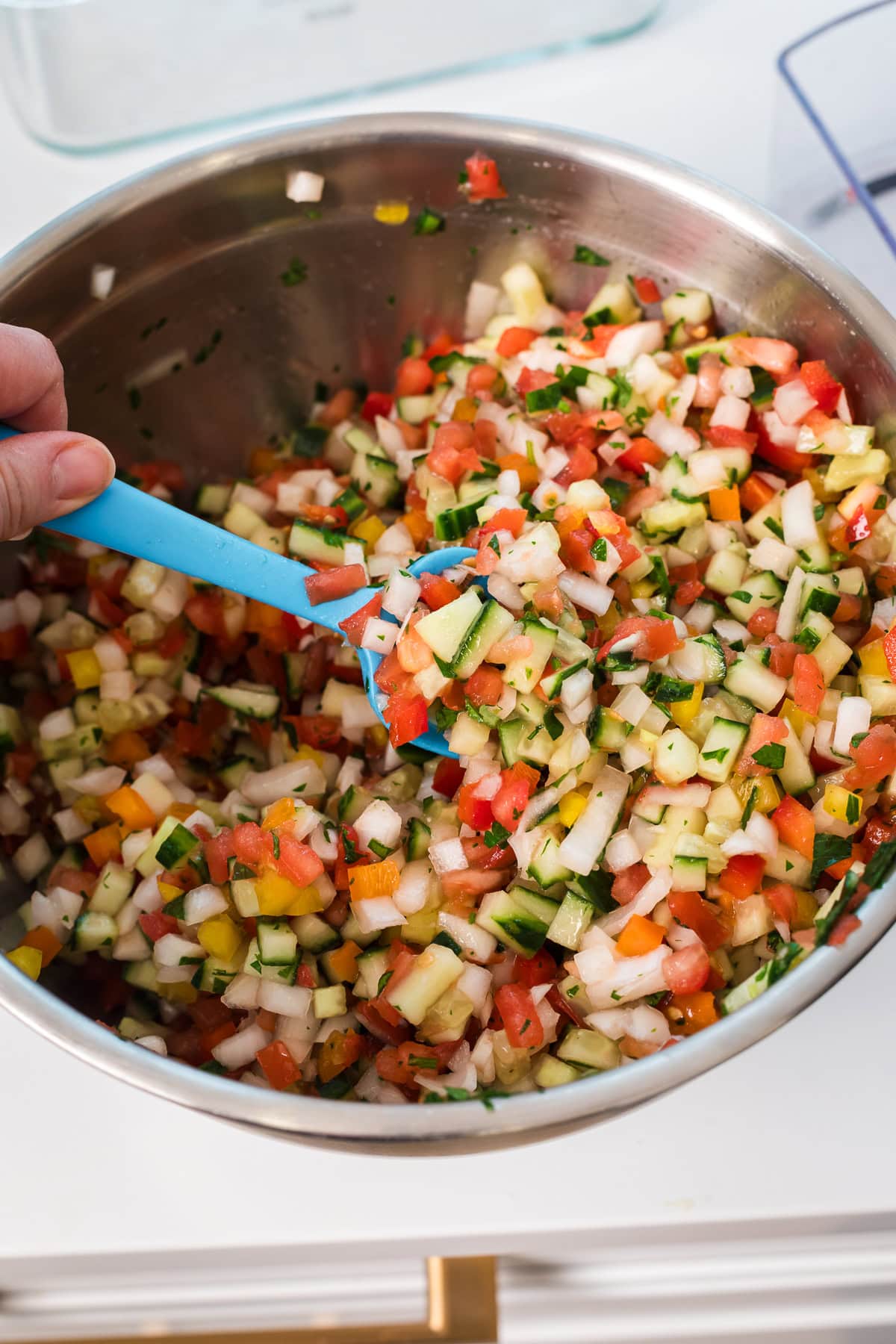hand holding spoon scooping middle eastern salad.