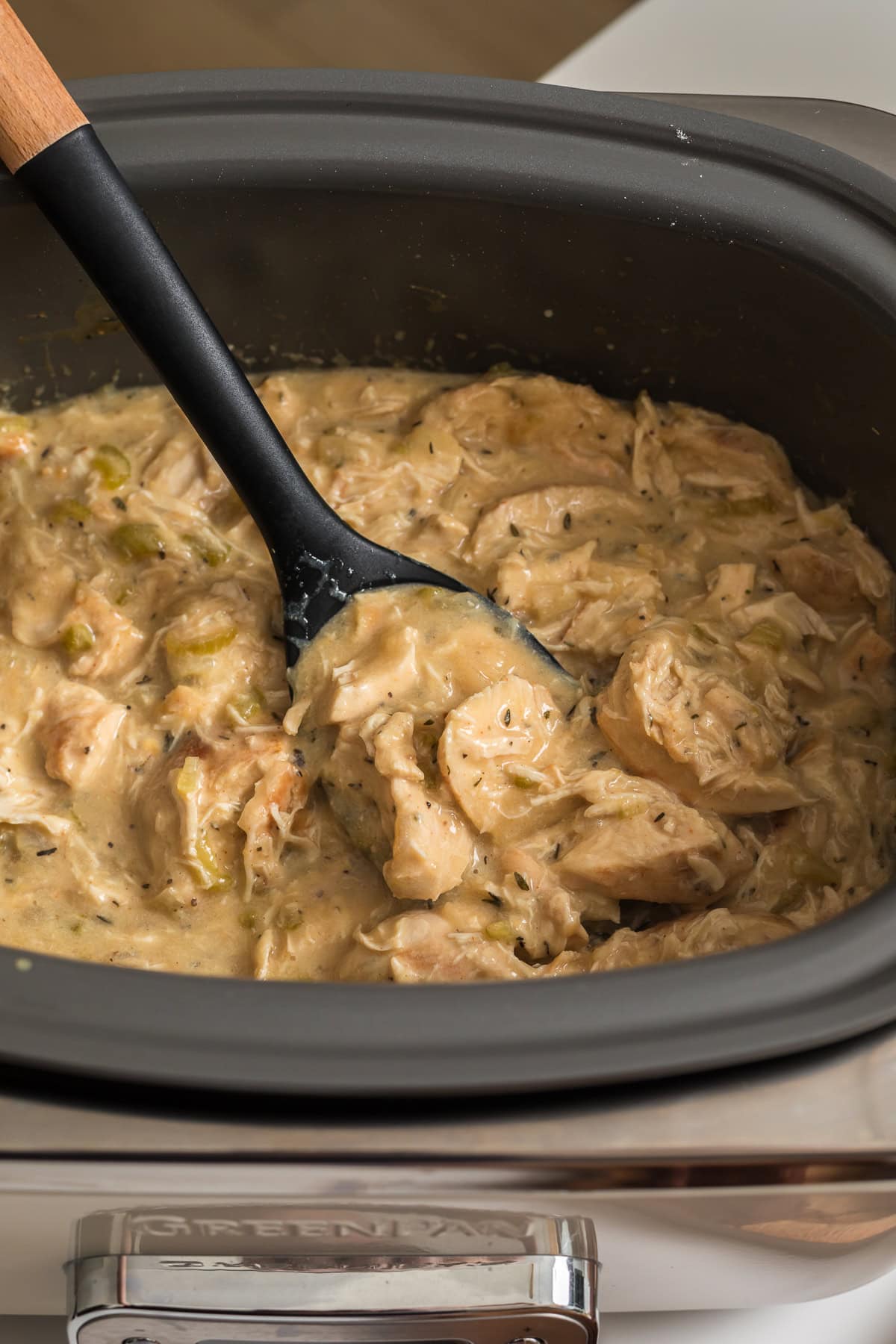 Creamy slow cooker chicken with celery and herbs cooking in the greenpan slow cooker.